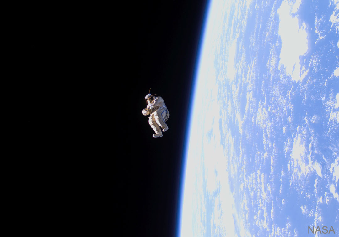 一件太空服漂浮在地球上空。请参阅说明。