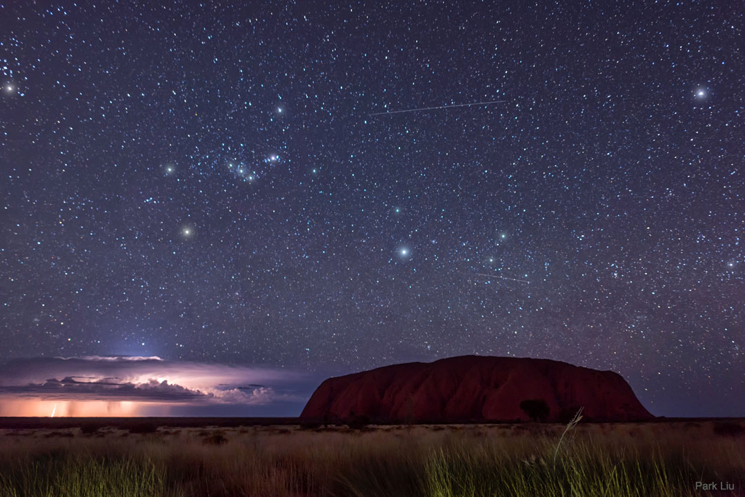 澳大利亚的乌鲁鲁在闪电和猎户座前的照片。请参阅说明以获取更多详细信息。