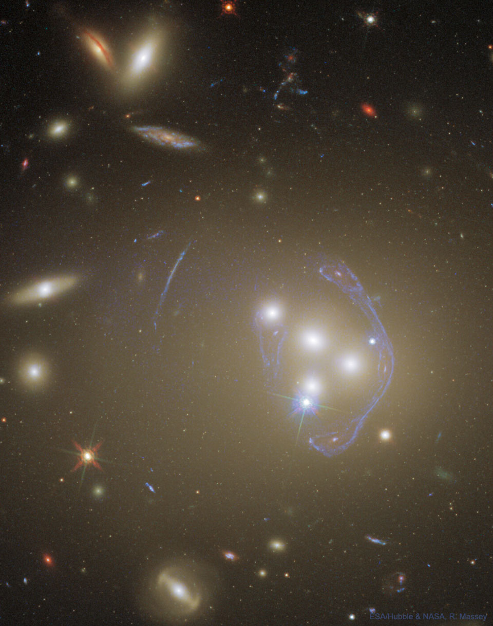 图为来自哈勃望远镜拍摄到的星系团Abell 3827。在图片中可以看到星系团在合并，并且可以看到背景星系的复杂图像，其中星系团充当引力透镜。有关更多详细信息，请参阅说明。