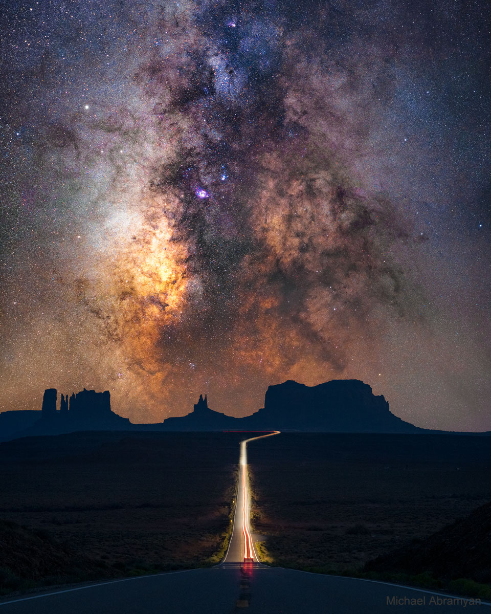 图为前景是美国犹他州纪念碑谷的合成图像，背景是包括银河系中心在内的银河系平面。有关更多详细信息，请参阅说明。