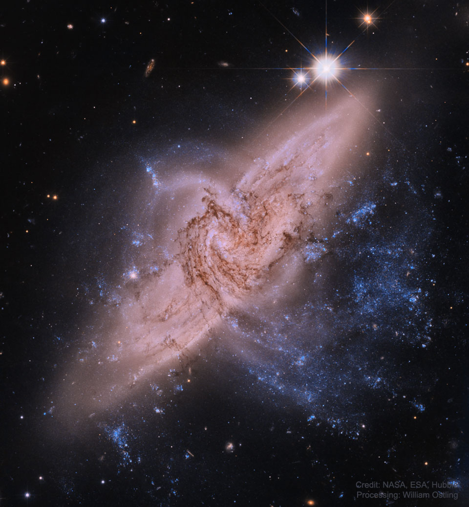 哈勃望远镜拍摄的图像显示，两个螺旋星系直接重叠在一个名为NGC 3314的星系中。有关更多详细信息，请参阅说明。