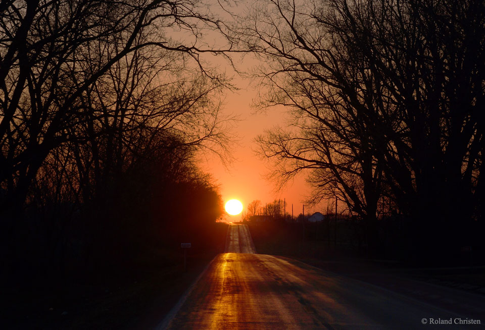 特色图片描绘了伊利诺伊州乡村公路上的日落。在春分时，太阳升起并落下，像这样东西走向的道路。许多城镇都有。更多详细信息,请参阅说明。