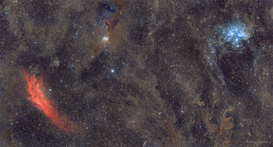 这张特色图片显示了一片广阔的视野，最左边是红色的加州星云，右边是蓝色的昴宿星团，中间有许多棕色的星际尘埃。请参阅说明以获取更多详细信息。