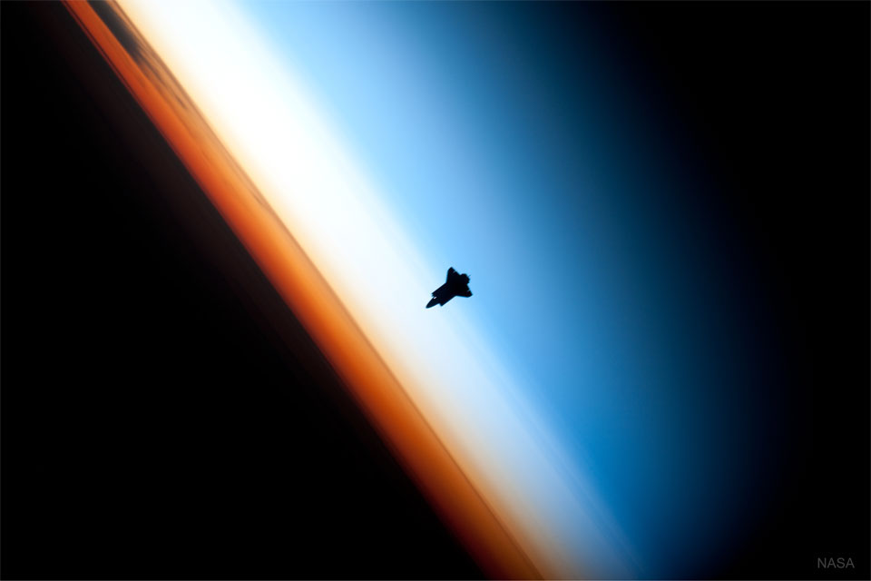 特色图片显示NASA航天飞机正在接近国际空间站，背景是地球大气层。请参阅说明以获取更多详细信息。
