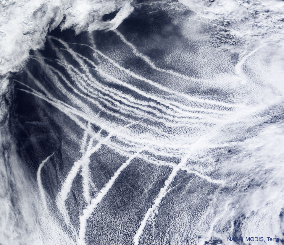 NASA Terra卫星上的MODIS仪器拍摄到的特色图像显示了船舶在太平洋上空的轨迹。轨迹在蓝色海洋上显示为白色条纹。请参阅说明以获取更多详细信息。