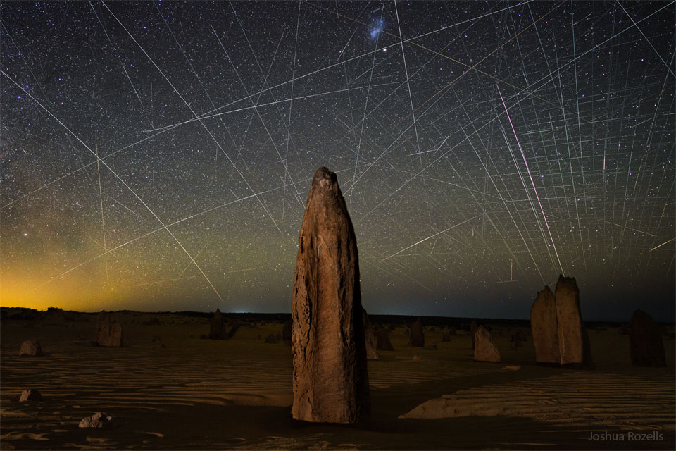 特色图片显示了澳大利亚出现的被称为尖峰石阵的岩石尖顶。尖顶后面是一片充满卫星轨迹的天空，其中包括许多来自Starlink的低地球轨道卫星。请参阅说明以获取更多详细信息。