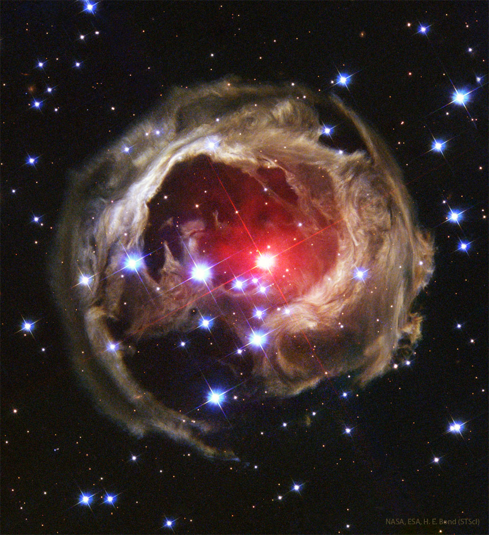 特色图像显示了称为麒麟座V838星的不寻常的回光结构。被照亮的尘埃是斑驳的，围绕着一颗明亮的红色恒星。请参阅说明以获取更多详细信息。