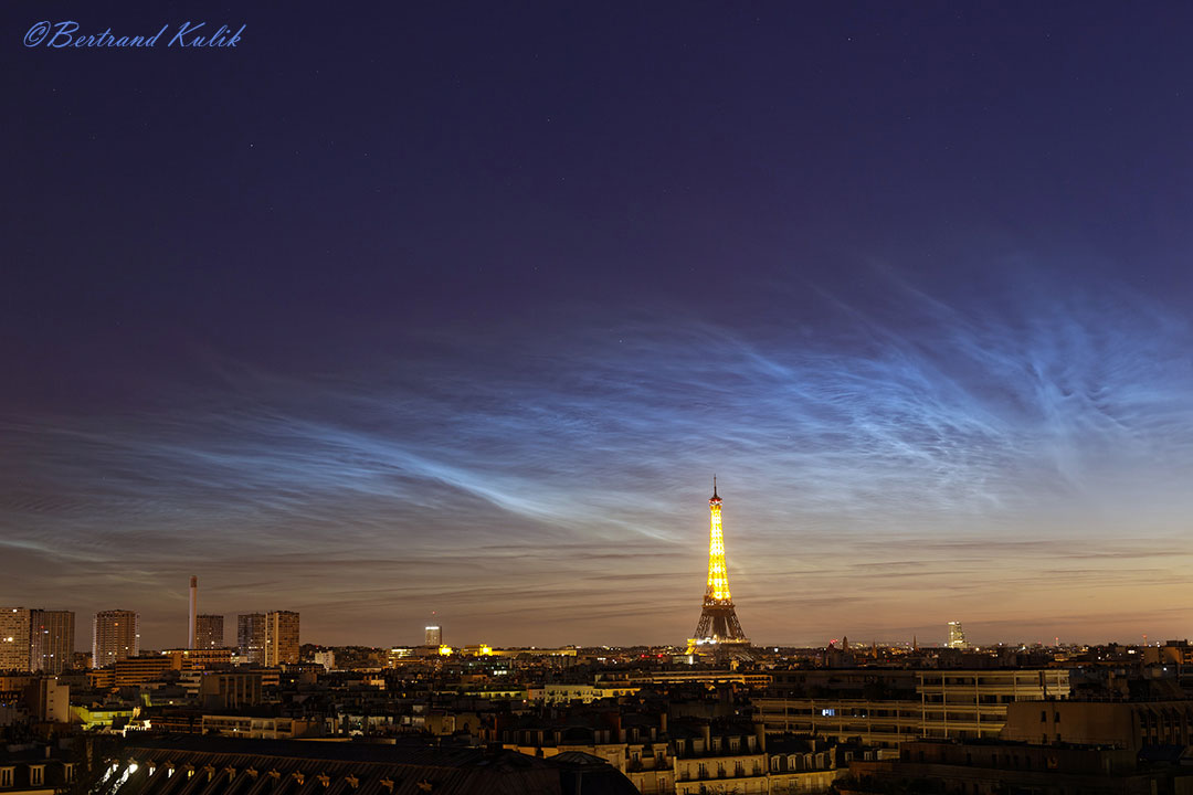 特色图片展示了法国巴黎的埃菲尔铁塔，下方是一片广阔的发光夜光云。请参阅说明以获取更多详细信息。
