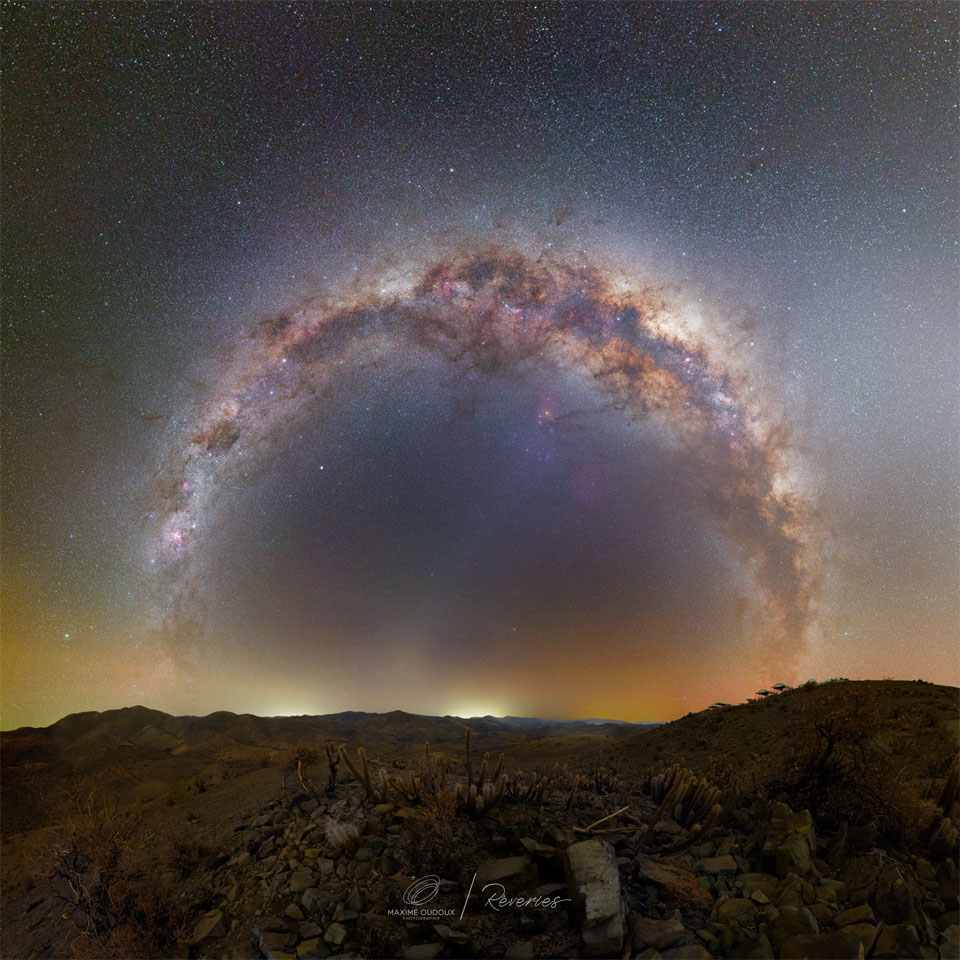 特色图像显示了一个圆形的恒星环，它是我们银河系中心带的投影。前景是来自智利高原沙漠的岩石和仙人掌。请参阅说明以获取更多详细信息。