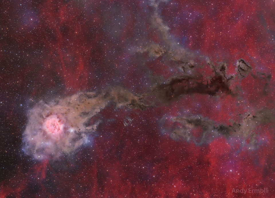 这张特色图片显示了白色和红色茧状星云，在发光的红色背景中，右边有一条棕色尘埃的尾迹。有关详细信息，请参阅说明。