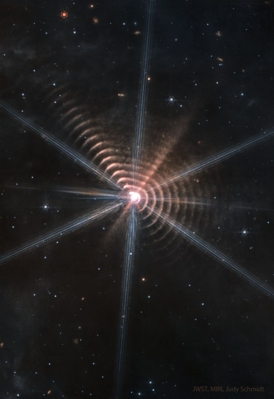 这张特写图片显示了围绕中心恒星的许多尘埃环。其他恒星在其他黑暗的区域也可以看到。有关详细信息，请参阅说明。