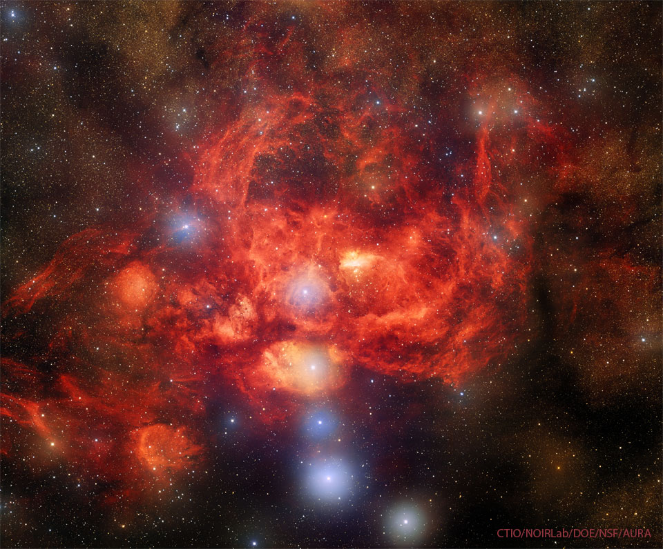 这张特色图片是龙虾星云，恒星场中有几颗明亮的蓝色恒星，被一个发光的红色星云包围，可以想象成一只龙虾。有关更多详细信息，请参阅说明。