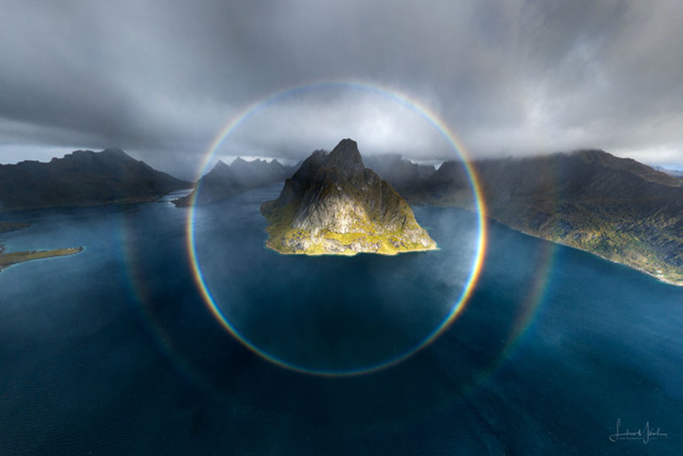 特色图片显示了两个完整的圆形彩虹，以一个多山的岛屿为中心。有关更多详细信息，请参阅说明。
