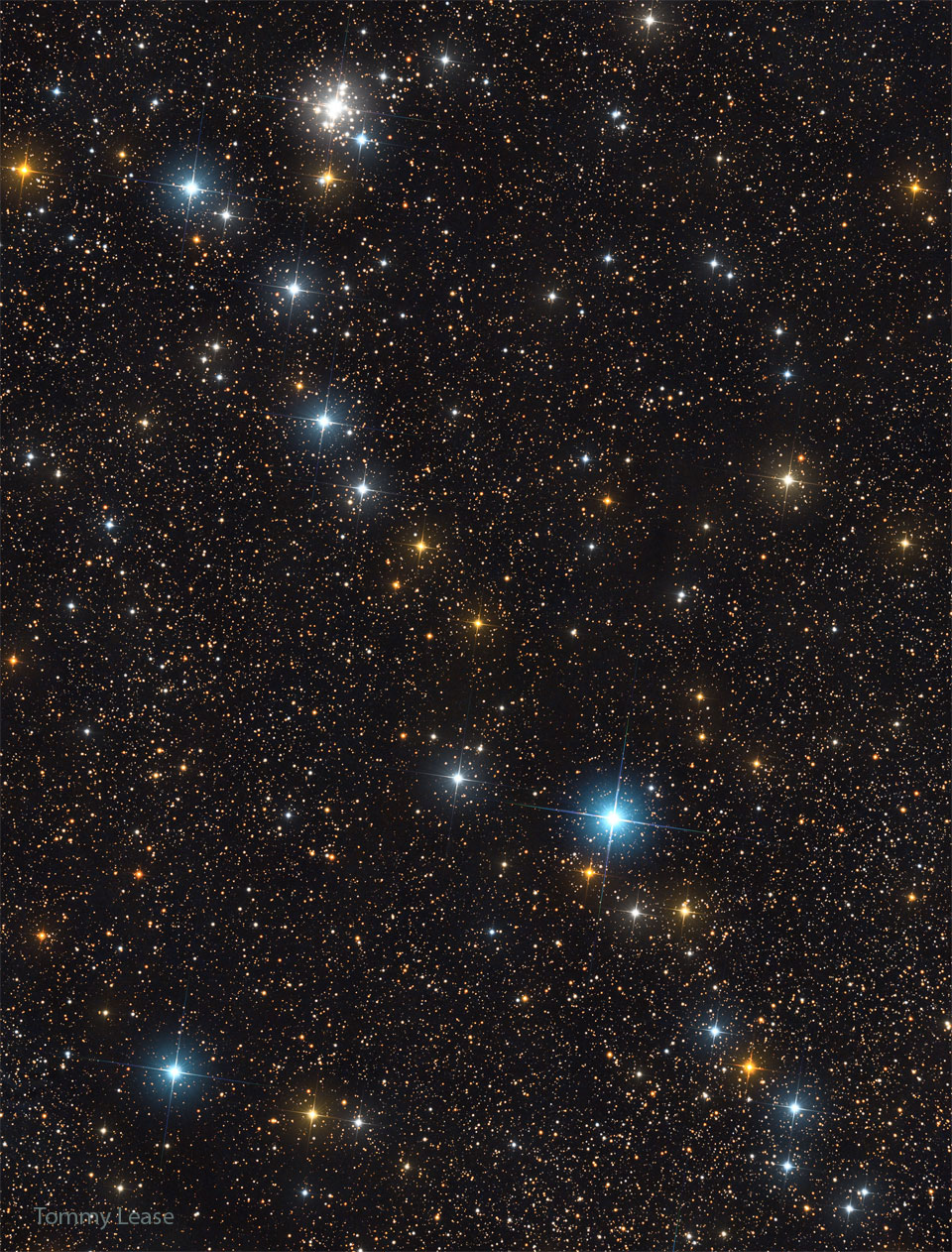 这张特色图片显示了一行明亮的恒星斜向散布在一个由更暗的恒星组成的星场上。在图像左上方附近也可以看到一簇恒星。有关更多详细信息，请参阅说明。