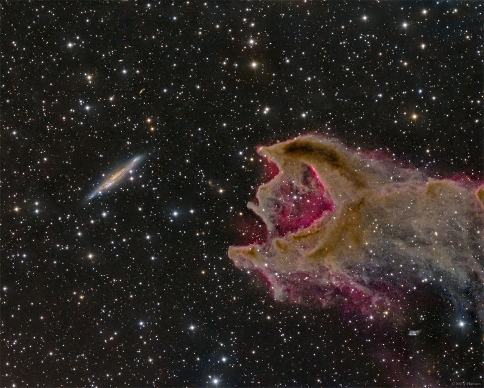 这张特色图片显示，左边是一个遥远的星系，右边是一个云气团。云气团中的一个开口与星系在同一侧。有关更多详细信息，请参阅说明。