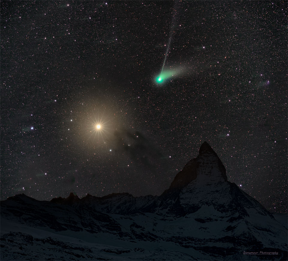 一个深邃的星场展示了左边橙色的火星和右边绿色的ZTF彗星。前景中的风景包括著名的马特洪峰。有关更多详细信息，请参阅说明。