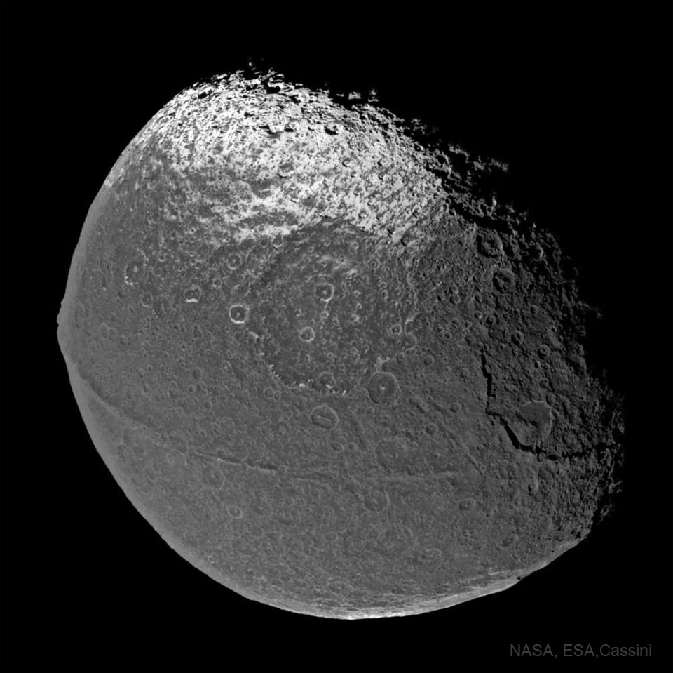 图中是一个不同寻常的双色球。这颗球，土星的卫星土卫八，有许多陨石坑和一条沿着赤道延伸的不同寻常的山脊，使它看起来像一颗核桃。有关更多详细信息，请参阅说明。