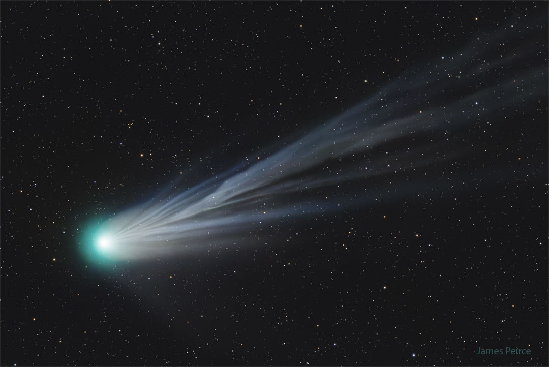 图中显示了一颗大彗星，其头部靠近右侧，浅蓝色的离子尾流穿过图像的其余部分。有关更多详细信息，请参阅说明。
