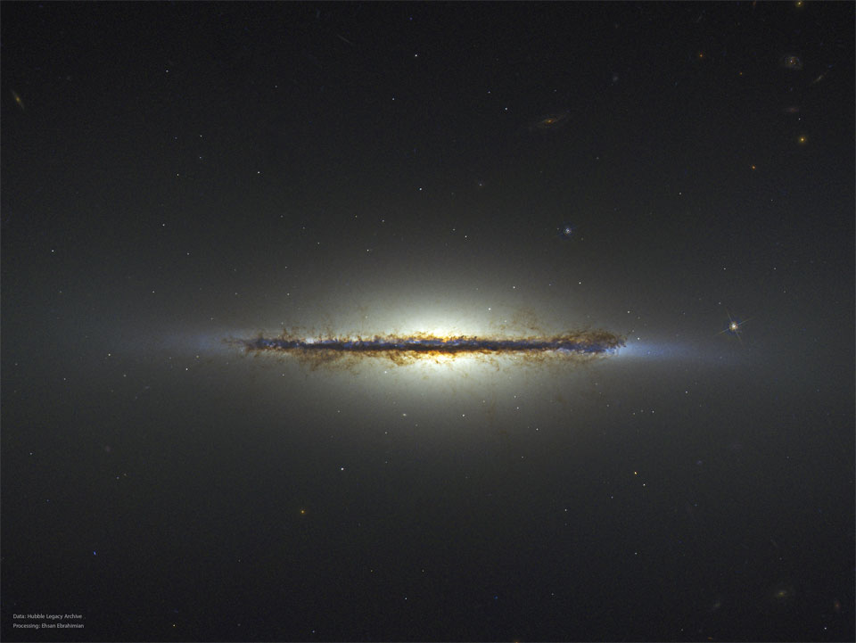 图中显示的星场中间有一条不寻常的水平线。这段是一个侧向星系，可见许多棕色尘埃细丝。有关更多详细信息，请参阅说明。