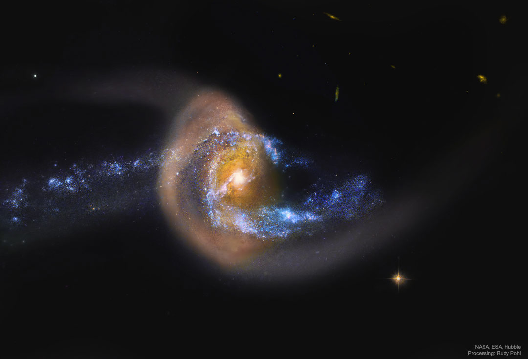 一个蓝色的螺旋星系似乎正在与一个满布尘埃的棕色星系碰撞，并且可能正在穿过这个星系。有关更多详细信息，请参阅说明。